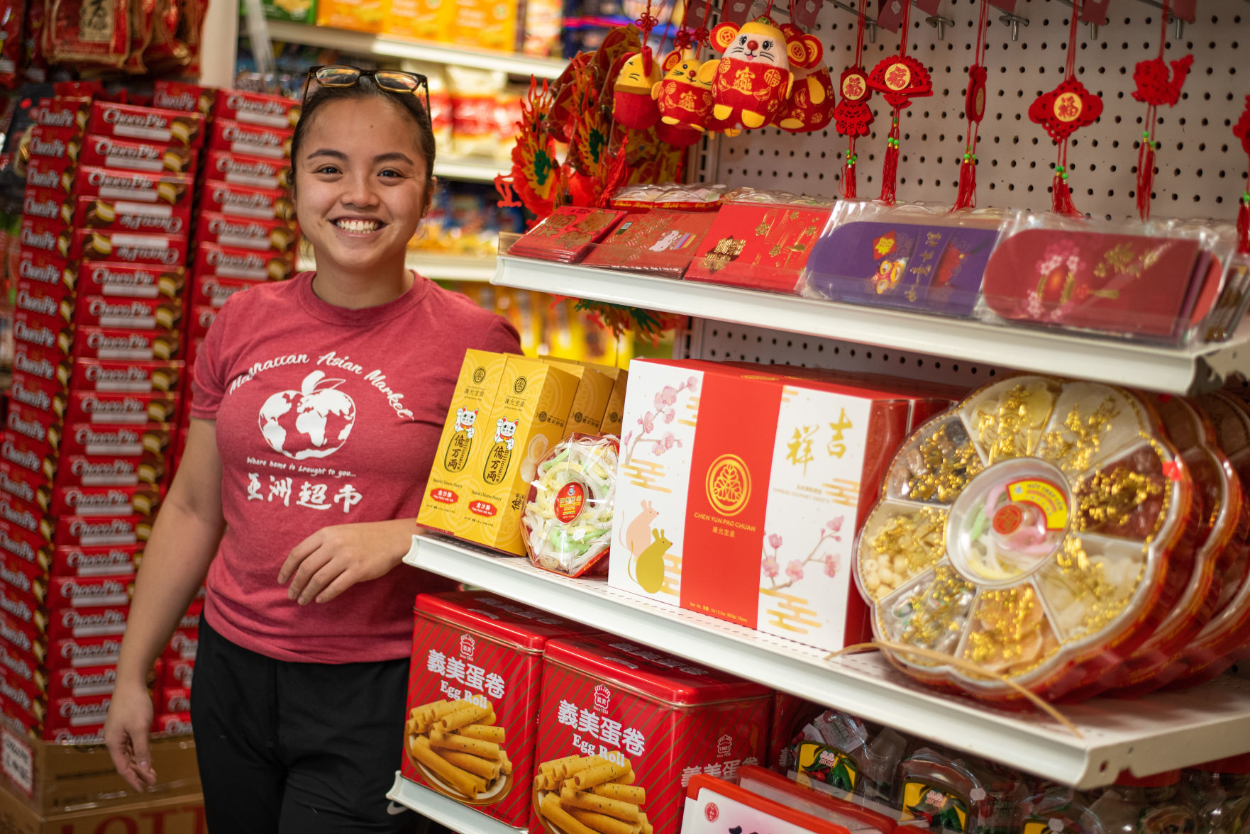 Fanny Fang stands next to the Chinese New Year decorations on display at the Asian Market.